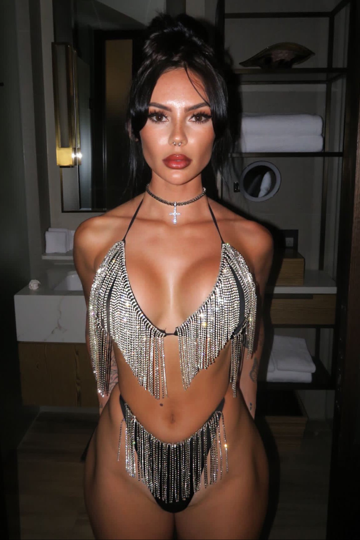 Person wearing a sparkling silver bikini in a room setting.